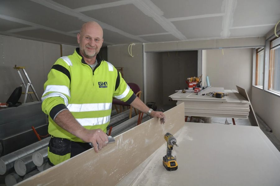 Montør fra GHV smiler på jobb i et næringsbygg – GHV fikk ny nettside av DIGSTRA